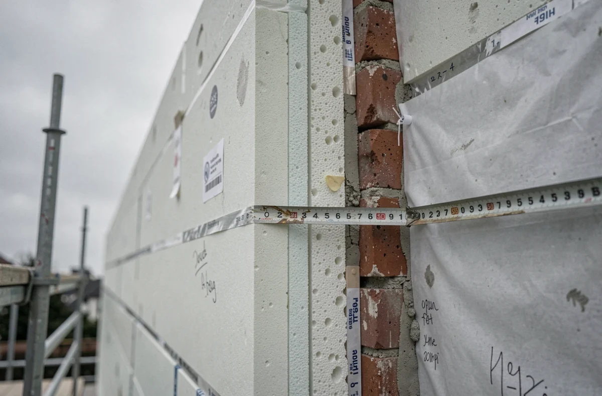 Coupe transversale d'un mur extérieur en rénovation montrant les couches d'isolation thermique, pare-vapeur et brique